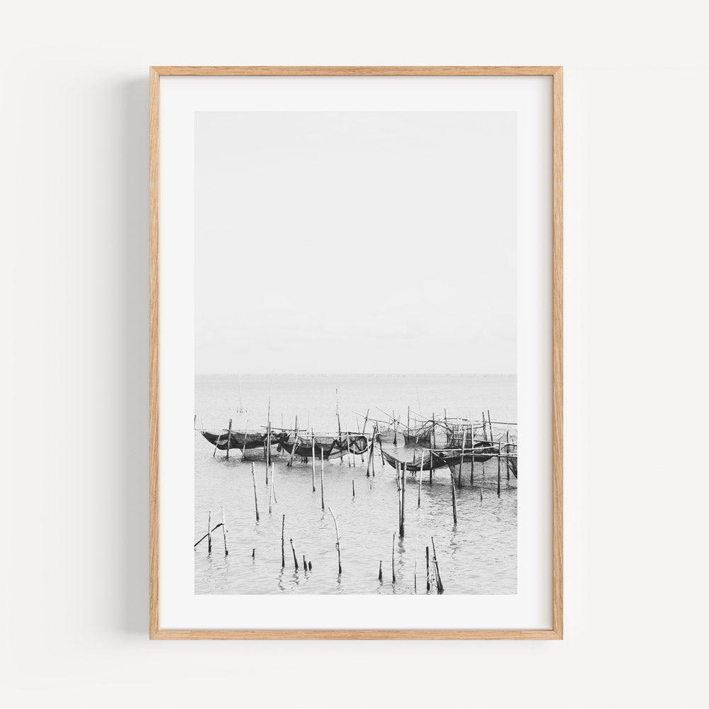 Serene Coastal Scene: Black and White Fishing Boats Reflected in Tranquil Waters