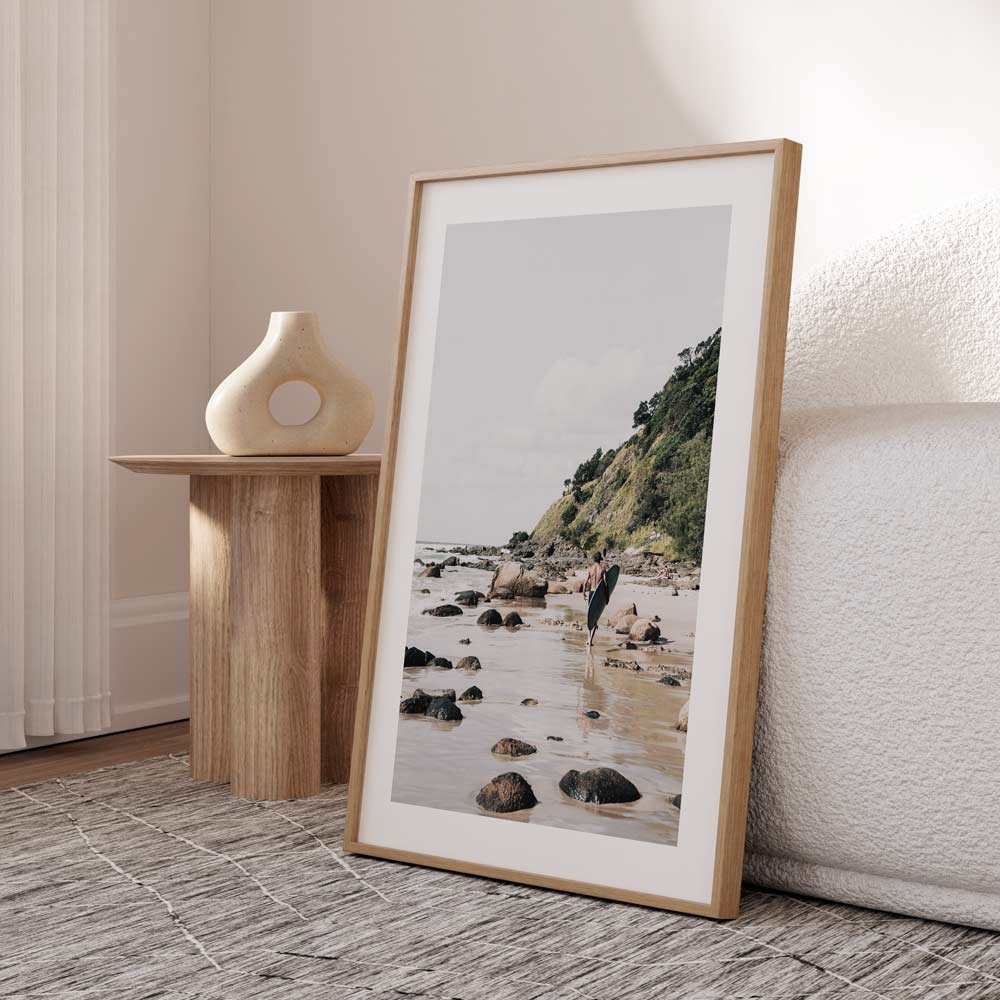 Serene Beach Adventure: Coastal Surfer Walking Along Rocky Shoreline