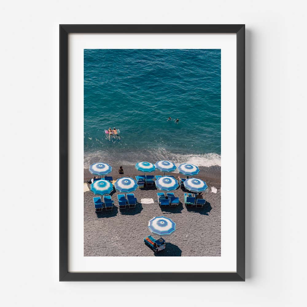 Vibrant Beach Scene with Blue Umbrellas and Swimmers