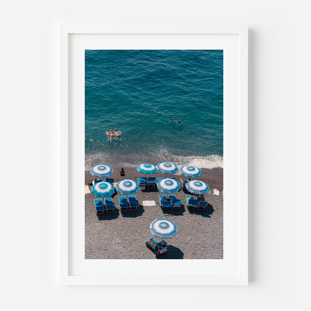 Vibrant Beach Scene with Blue Umbrellas and Swimmers