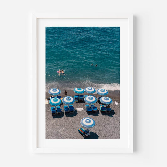 Vibrant Beach Scene with Blue Umbrellas and Swimmers