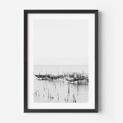 Serene Coastal Scene: Black and White Fishing Boats Reflected in Tranquil Waters