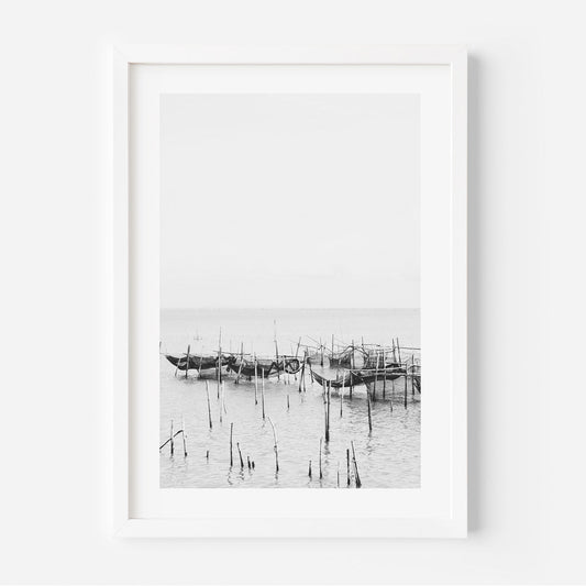 Serene Coastal Scene: Black and White Fishing Boats Reflected in Tranquil Waters