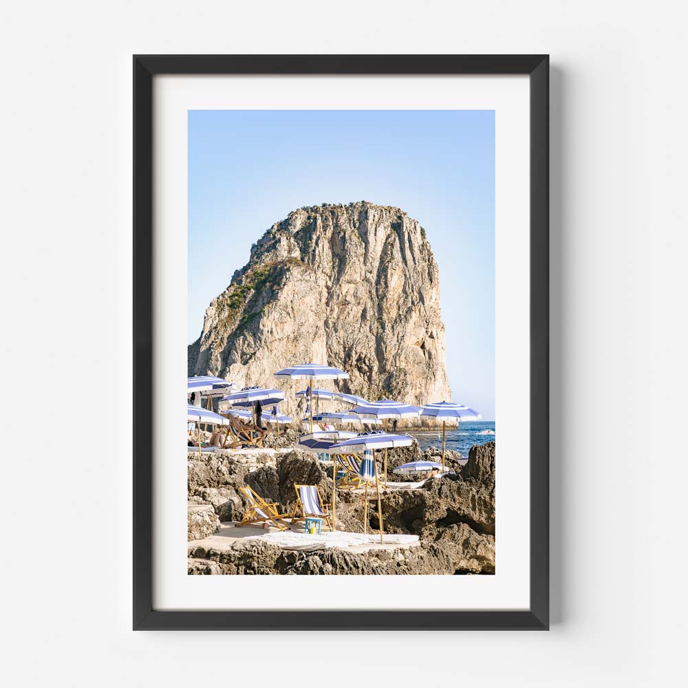 Serene Coastal Escape with Umbrellas and Rocky Cliff in Tranquil Seascape