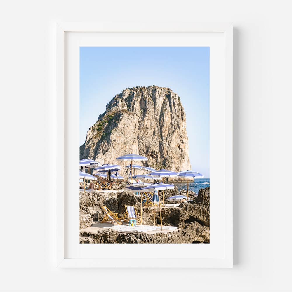 Serene Coastal Escape with Umbrellas and Rocky Cliff in Tranquil Seascape