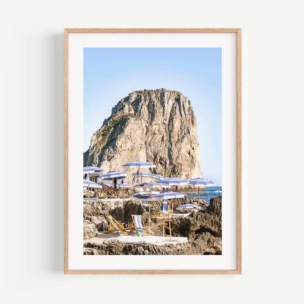 Serene Coastal Escape with Umbrellas and Rocky Cliff in Tranquil Seascape