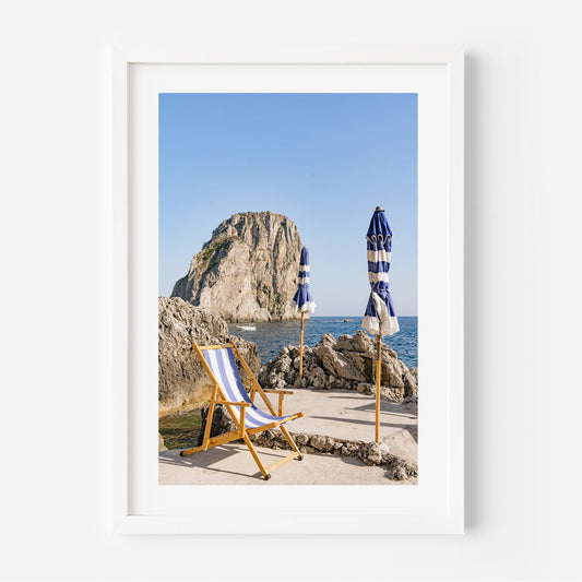 Charming Coastal Retreat: Serene Beach Scene with Umbrellas and Rock Formation